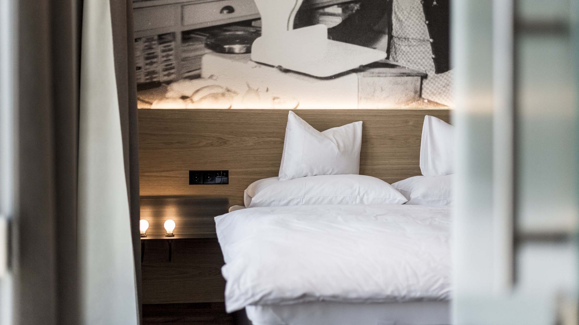 Camera d'hotel moderna con biancheria bianca e foto storica sulla parete